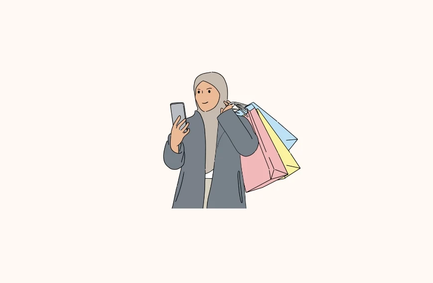 Illustration of a Muslim person wearing a hijab and a gray coat, looking at a smartphone in one hand while holding several colorful shopping bags (pink, blue, and yellow) in the other. The plain white background emphasizes the figure and their shopping activity.